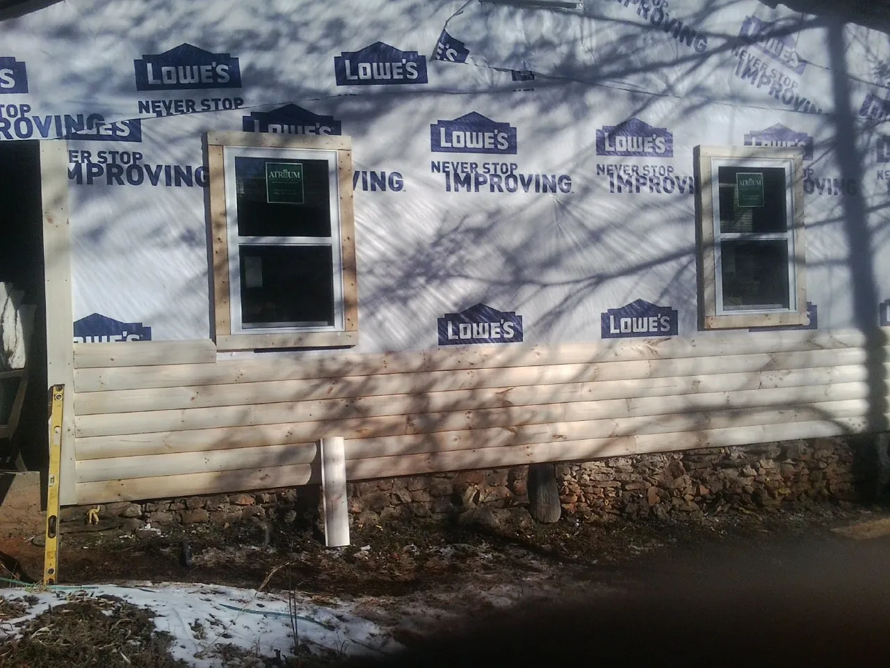 House wrap and new log siding going up on an exterior wall in Merchantville