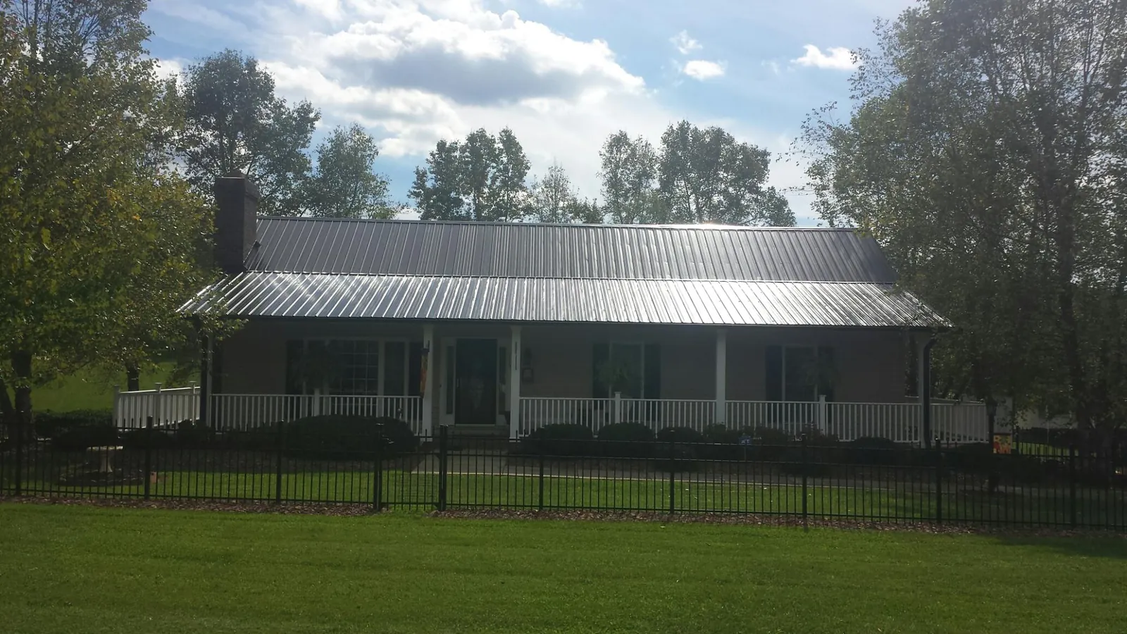 Gray metal roof on a brick ranch with a full width front porch — Gutter Guard Installation work by our crew in Merchantville