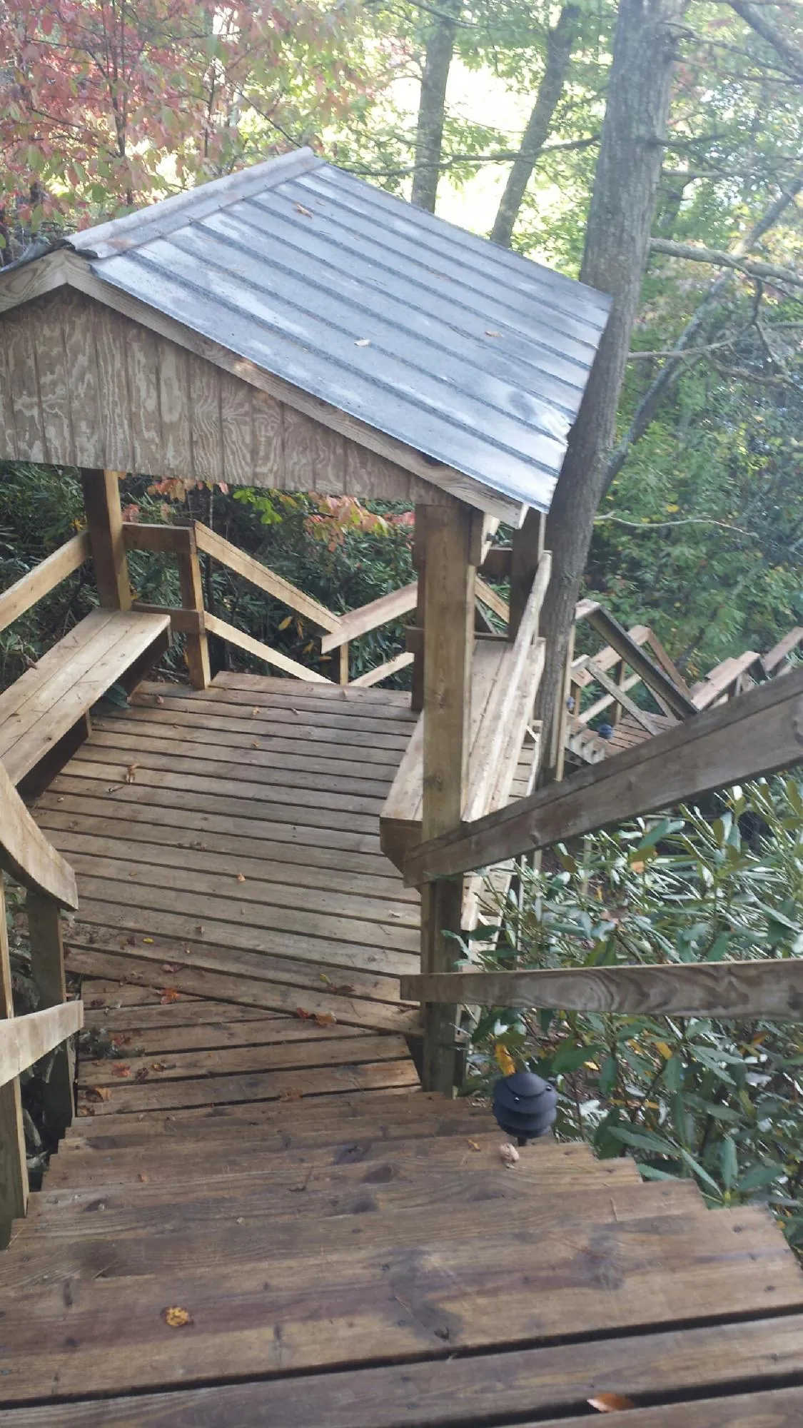 Metal roofed shelter over wooden steps on a wooded walkway — Skylight Repair & Installation work by our crew in Merchantville